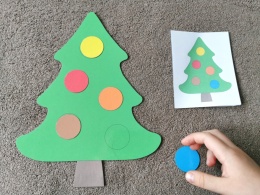 Dziecko układa kolorowe bombki według wzoru