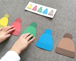 Dziecko układa kolorowe czapki według wzoru – zimowa układanka edukacyjna