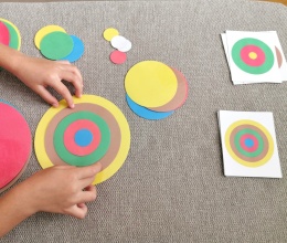Dziecko układa wzór z 5 kolorowych kół według karty – układanka lewopółkulowa