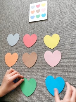 WDziecko układa serca według wzoru z edukacyjnej zabawy na walentynki